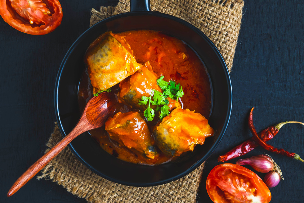 Fish with Tomato Sauce in a Pan with Spoon Flatlay