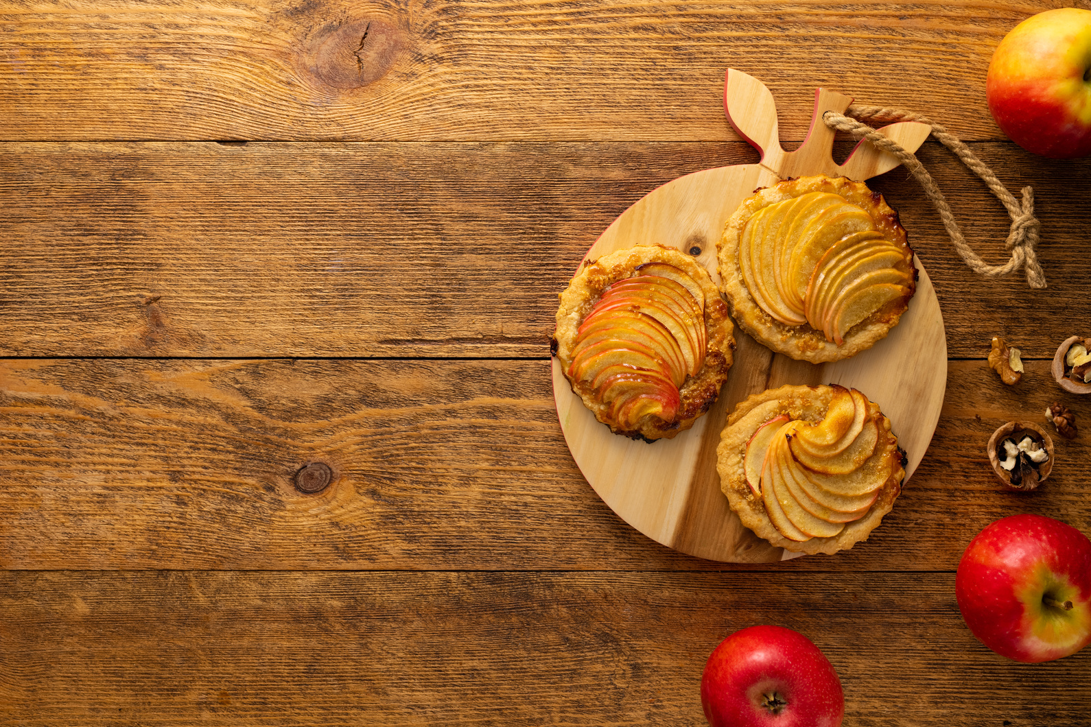 Mini Apple pie tartlets with walnut on wooden table. Delicious d